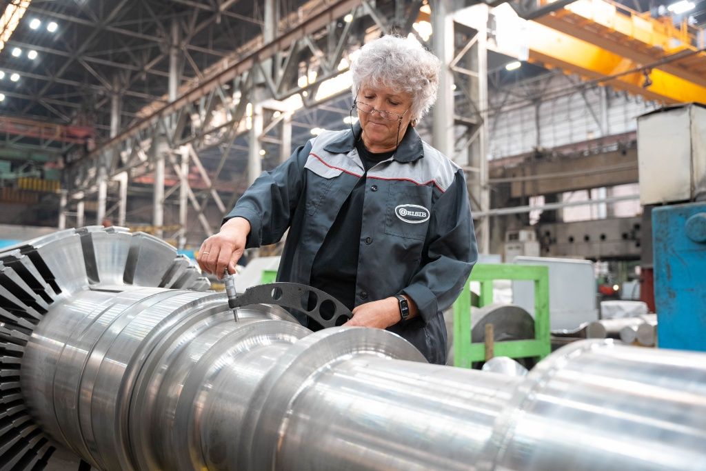 С помощью микрометра специалист измеряет шейку вала ротора — вращающейся части генератора С помощью микрометра специалист измеряет шейку вала ротора — вращающейся части генератора