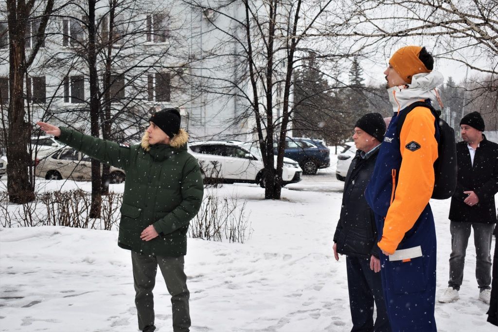 Заместитель главного инженера бийского теплосетевого подразделения СГК показывает участникам рабочей группы размещение сетевых трубопроводов на объекте