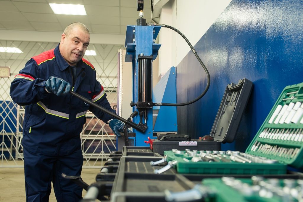 Автослесарь Сергей Будаев за работой на выжимном прессе для подшипников. Сергей работает здесь уже 17 лет