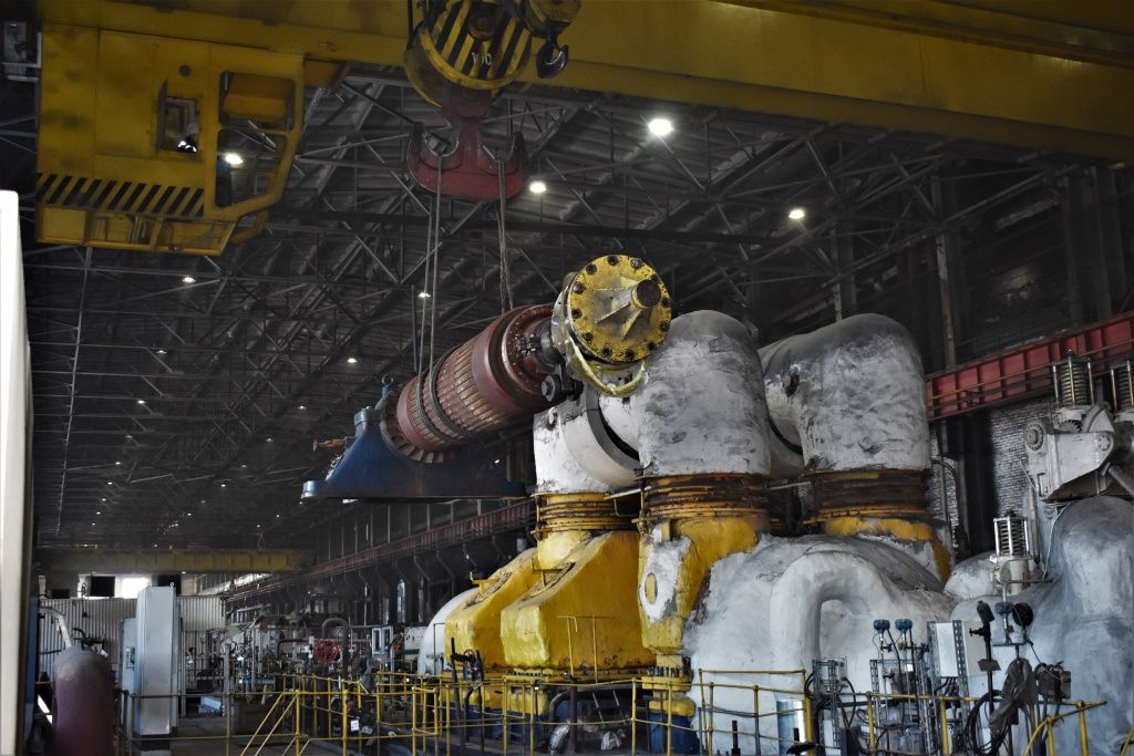 Грузоподъемный кран перемещает элемент турбины по производственному корпусу Бийской ТЭЦ для предстоящей погрузки 